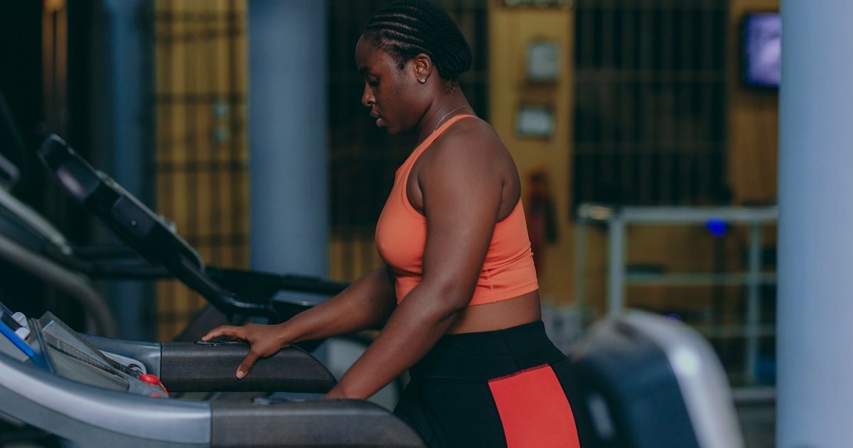 Mulher caminhando em esteira para perder barriga na academia