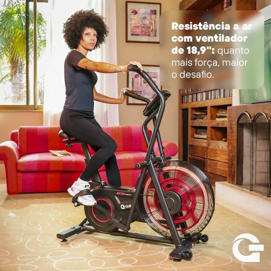 Mulher pedalando a air bike Gallant em uma sala, com a indicação de ventilador de 18,9 polegadas