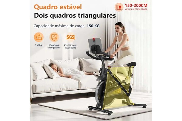 Bike de spinning MZY 680 em um quarto, com ilustração dos quadros triangulares estáveis e capacidade de 150 kg