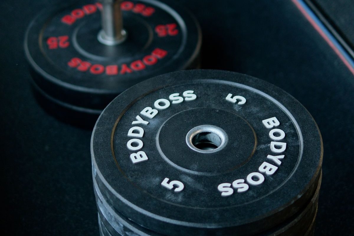Pilha de anilhas bumper de 5 kg empilhadas em piso de academia