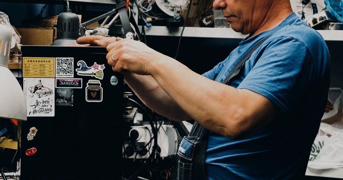 Mãos usando uma chave para ajustar peças em uma máquina