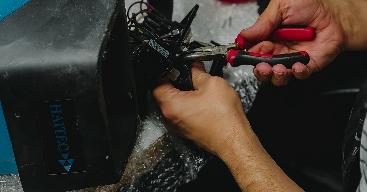 Mãos usando ferramentas para ajustar peças mecânicas