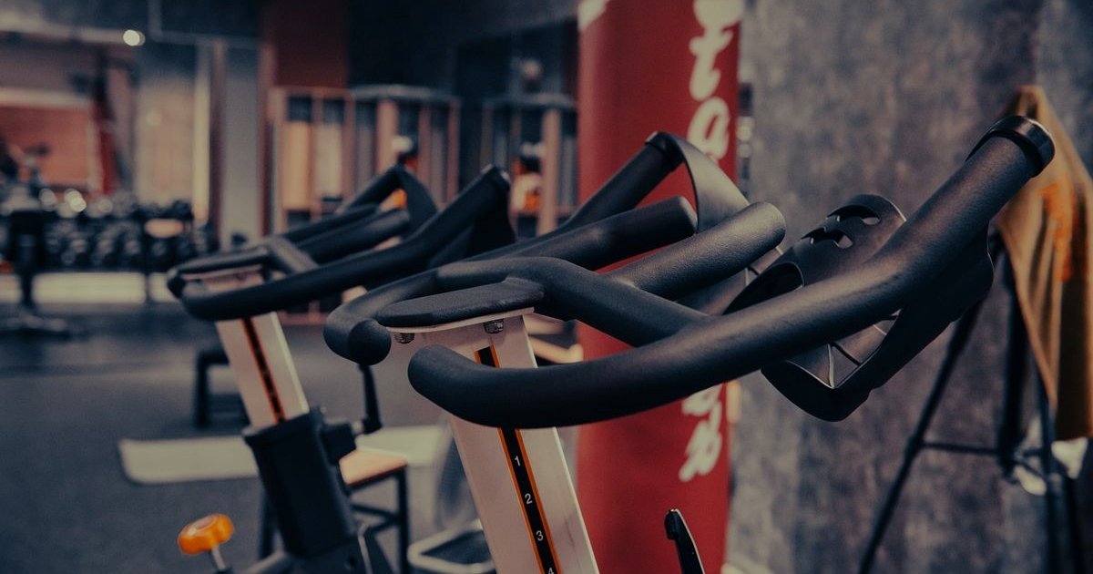 Fileira de bicicletas de spinning com guidões ajustáveis em uma academia