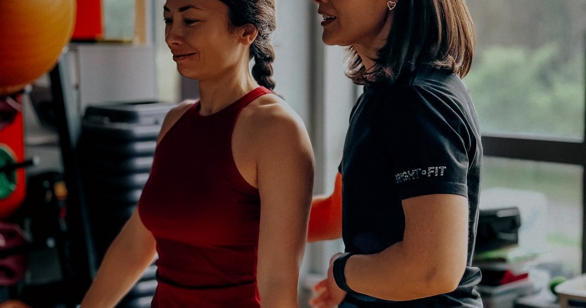 Personal trainer orientando uma aluna na academia