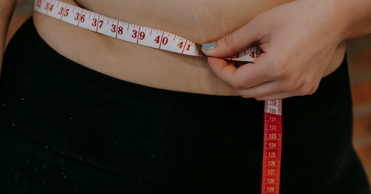 Fita métrica na cintura de uma pessoa