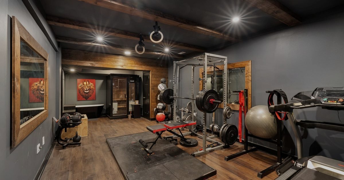 Home gym com rack, banco, bola e esteira, ambiente em que uma smith machine se encaixa